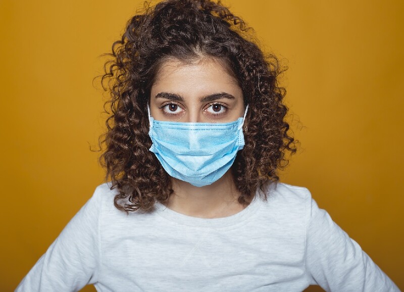 Woman of color wearing a face mask. Adobe Stock Photo