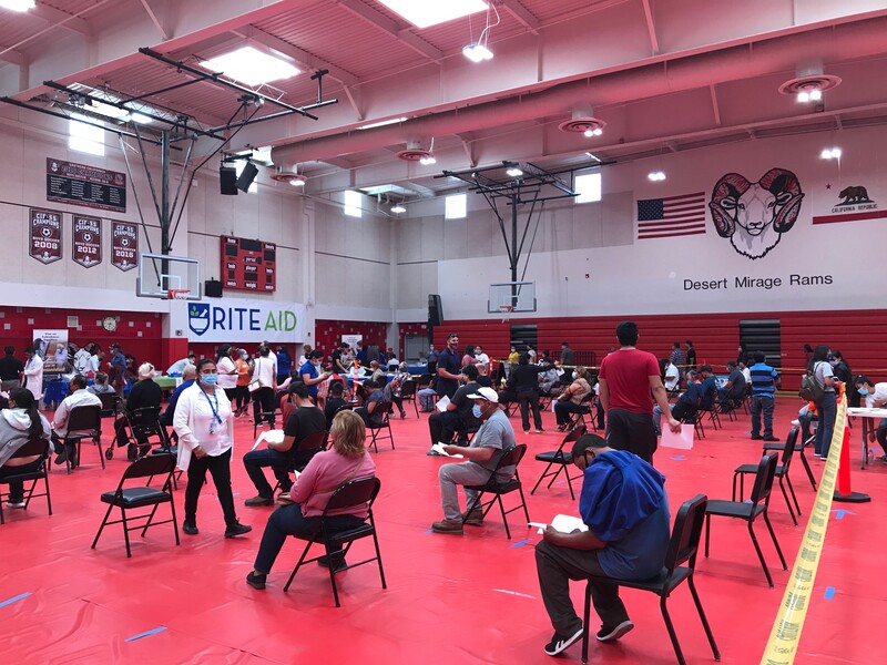 Residents sit in chairs for 15 minutes after getting the vaccine in the Desert Mirage High School gym.