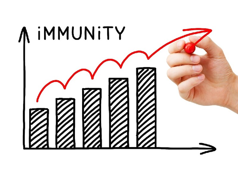 A hand holding a red marker illustrates upward trend toward herd immunity