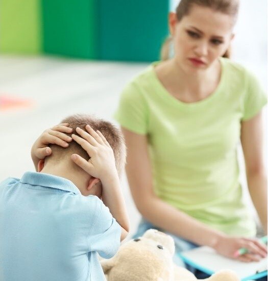 A mother looks at her son who covers his head. Stock Photo