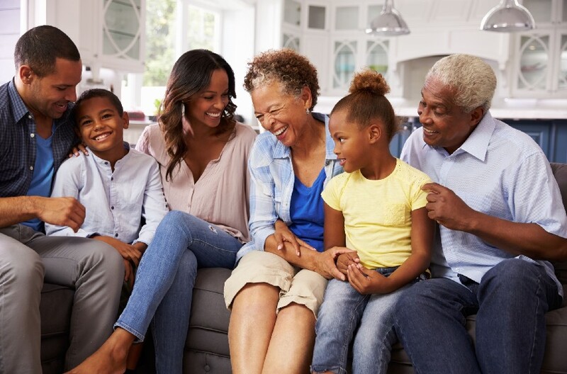 Generations of a happy Black family sitting on a sofa. Stock Photo
