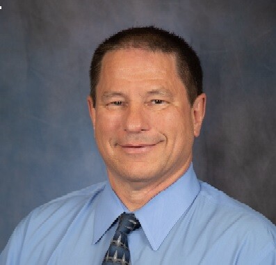 Chris Christensen, Desert Healthcare District & Foundation CAO Photo of CAO Chris Christensen smiling and looking at the camera. he wears a medium blue button-down shirt with a darker blue tie. Photo by Lani Garfield