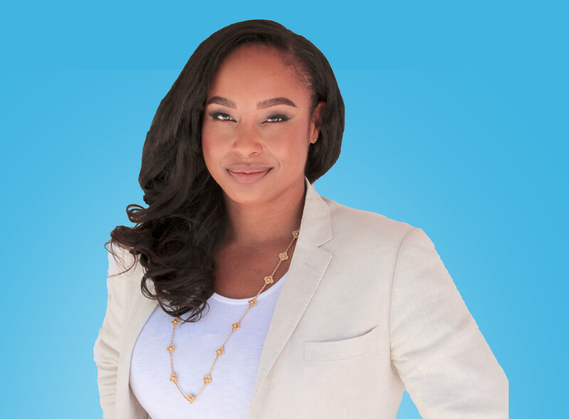 Portrait of woman facing the camera, wearing a white blouse under a light cream jacket, before a bright blue background.