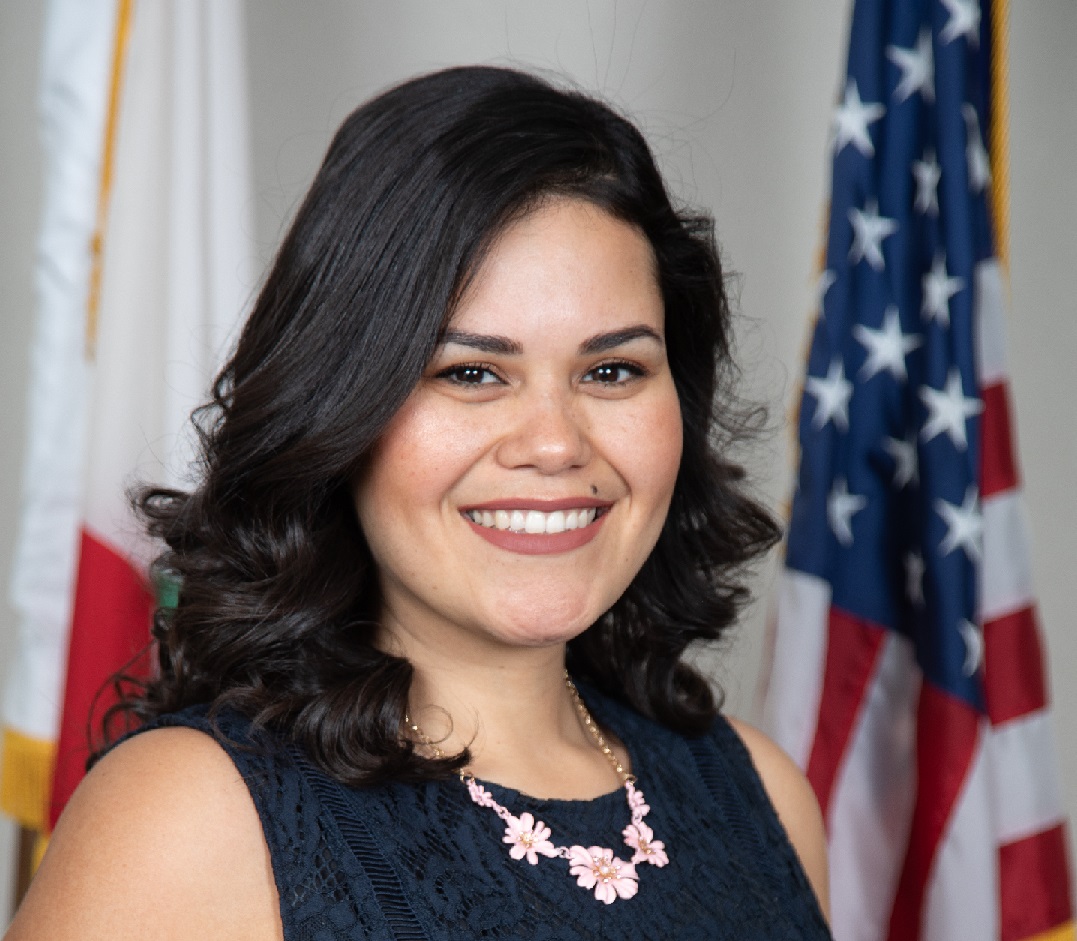 Board Vice-President Karen Borja with U.S. and California flags in background